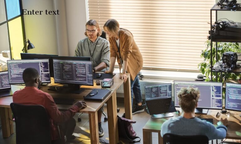 Developers coding on multiple desktop computers.