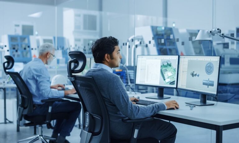 Two manufacturing engineers designing products on Windows 11 computers.