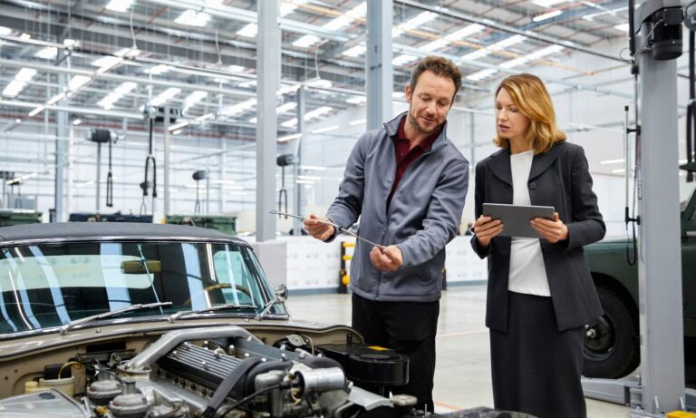 Automotive engineer showing dipstick to supervisor.