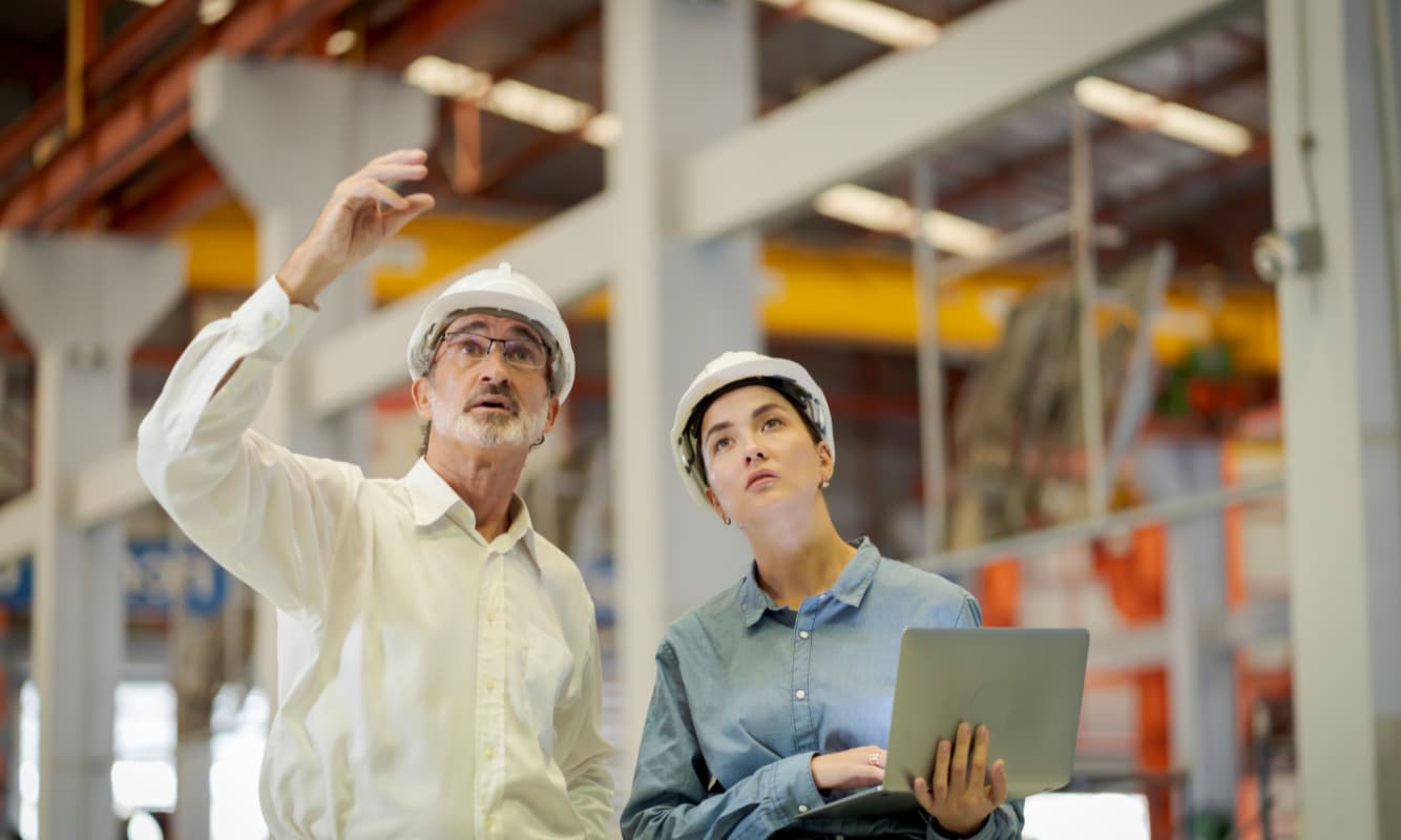 Two engineers having a conversation at a factory.