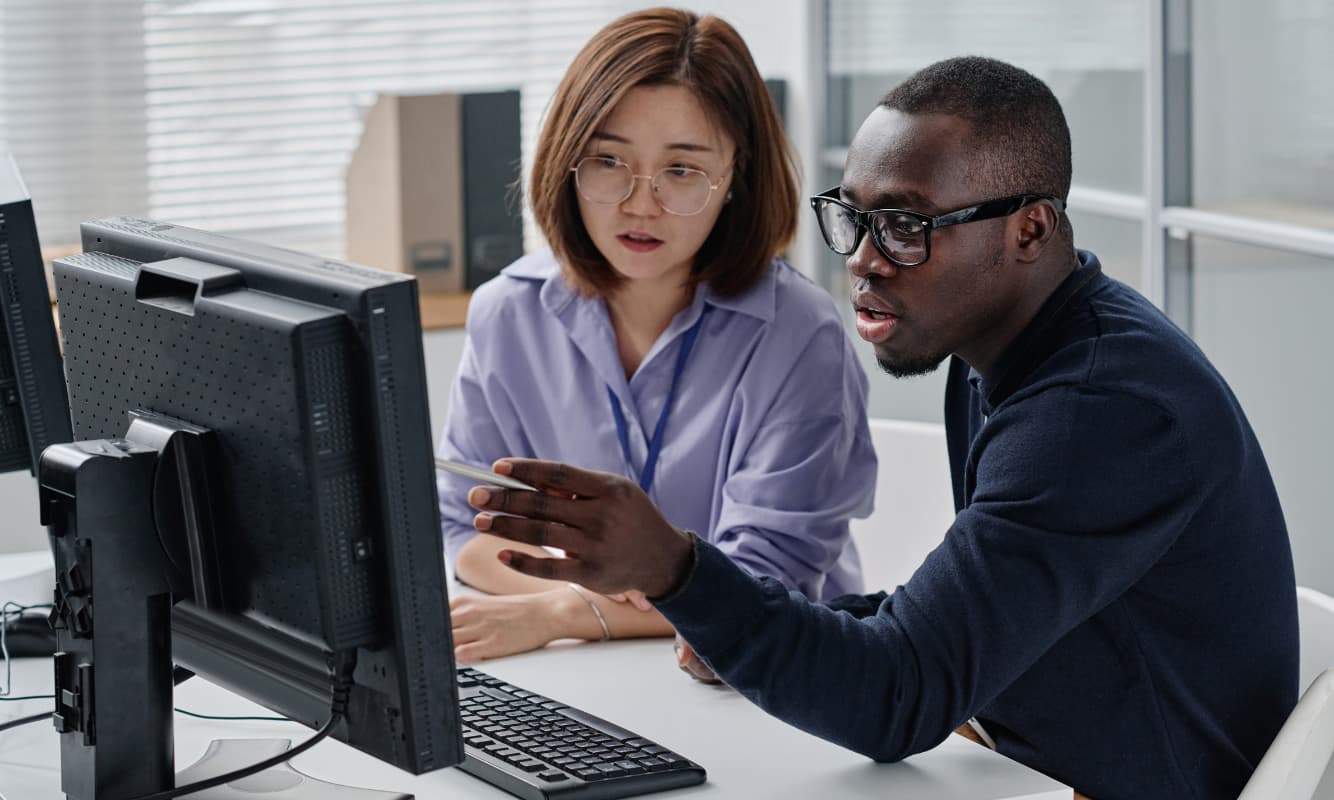 Two leaders looking at insights from their observability solution on a monitor