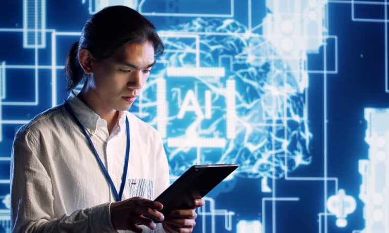 Software engineer holding tablet with a screen labelled “AI” on the background