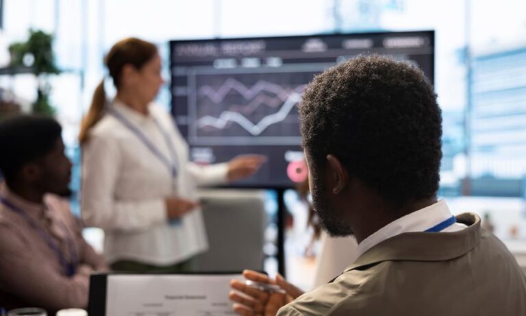 Business leaders looking at data insights on a dashboard.