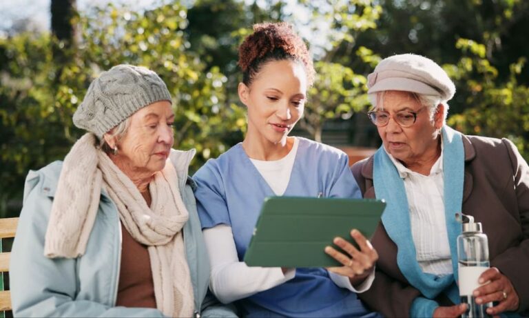 Caregiver showing elderly patients something on a tablet