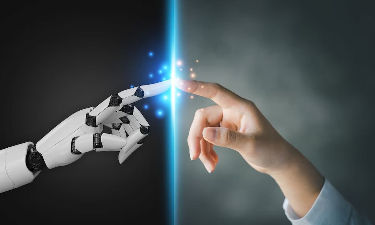 A robot hand and a human hand touch each other, and where they touch are sparks of light.
