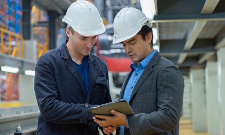 Engineers reviewing data on a tablet in a factory