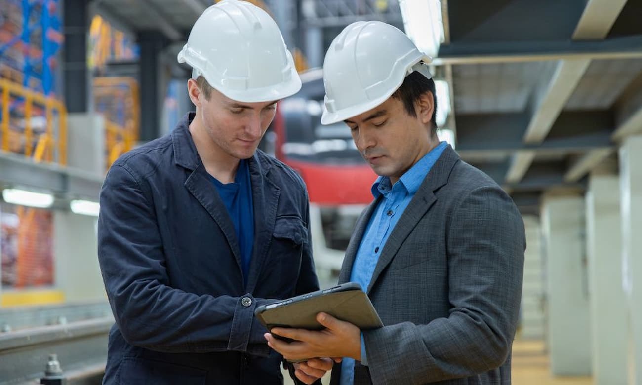 Engineers reviewing data on a tablet in a factory