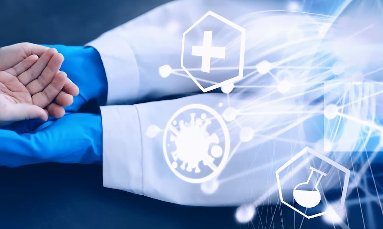 A healthcare worker wearing blue gloves examines a patient. The provider is in a white coat.