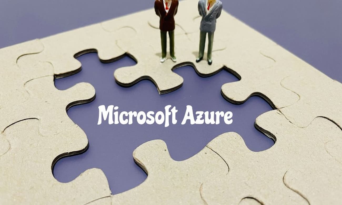 Miniature models of people stand on a puzzle with pieces missing. Where the pieces are missing, the words Microsoft Azure appear