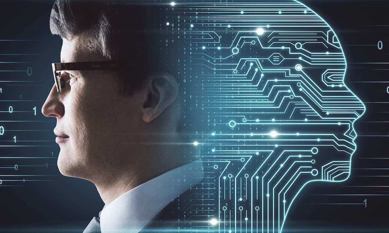 Profile view of a man with short dark hair wearing glasses and a suit. A glowing blue circuit board shaped like a face is superimposed on the right side of the image, with blue numbers scattered throughout.